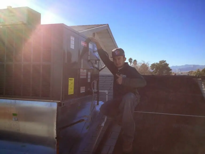 HVAC technician performing Heat Pump Repair on a rooftop unit in Plumas Lake